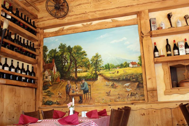 Dining room with a mural of the Italian countryside