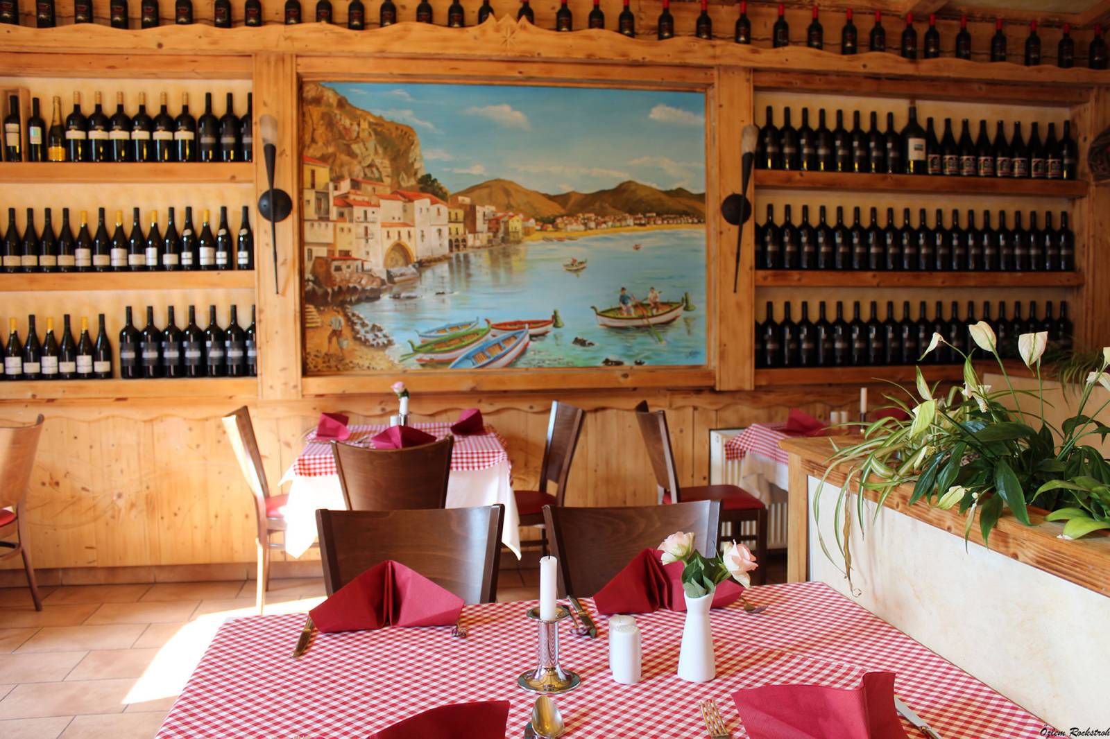 Dining room with wine racks and a mural of the Italian coast